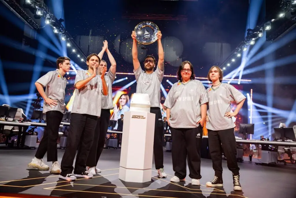 Team Spirit esports players celebrating on stage with a trophy at the Esports World Cup