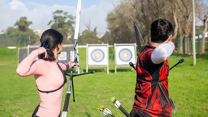 two people shooting arrows from a bow