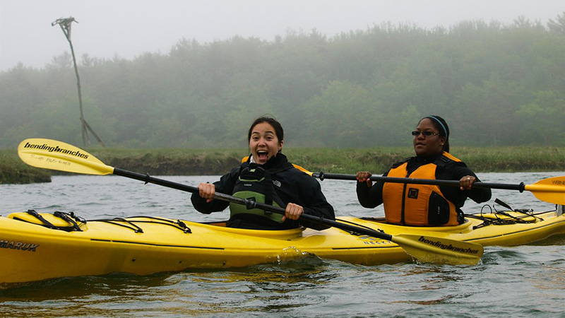 image showing two people in a kayak, smiling