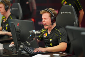 Esports player in headset shouting passionately while competing at his PC