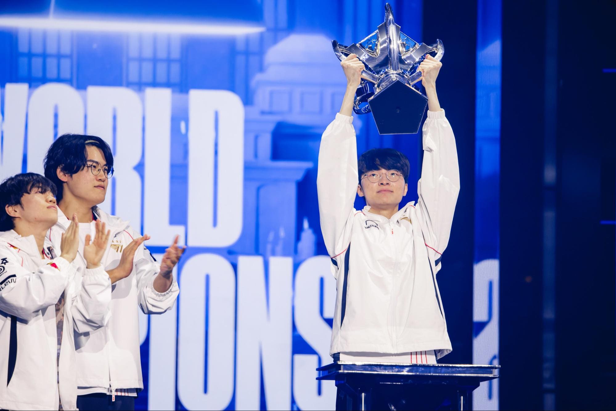 Faker lifting LoL Worlds trophy as teammates applaud