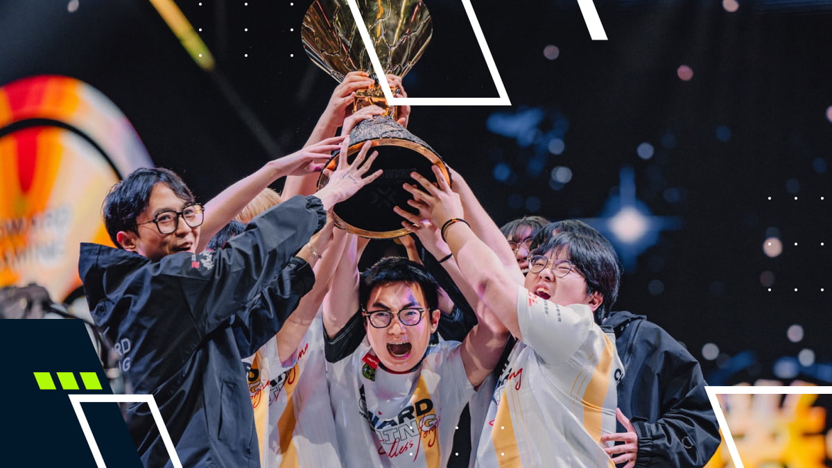 A jubilant esports team celebrates, holding up a large trophy together. They wear white jerseys with excitement and joy on their faces, under bright stage lights