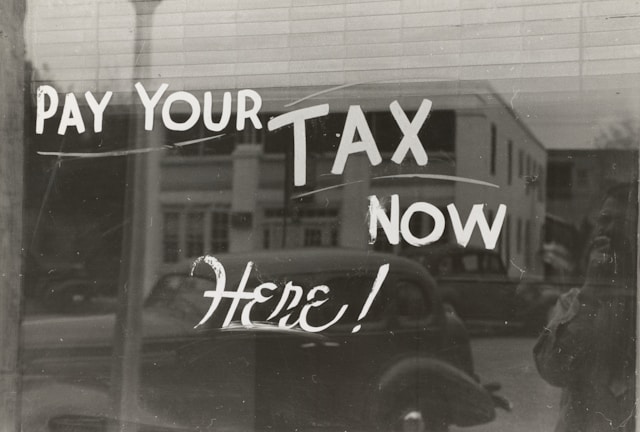 Pay your tax here now written on a window