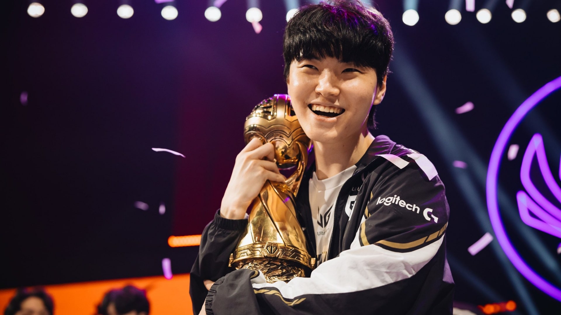 Gen.G Chovy smiling and holding a gold trophy on stage