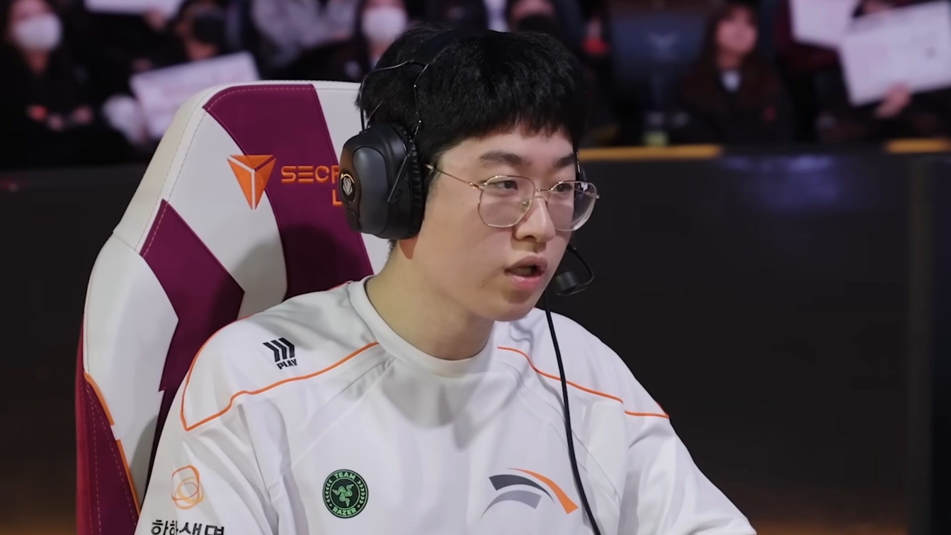 HLE Zeus playing on stage in team jersey and headset