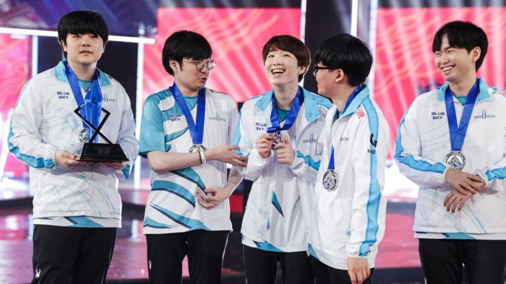 DAMWON Kia players celebrating their League of Legends Worlds 2020 victory with medals and MVP trophy on stage