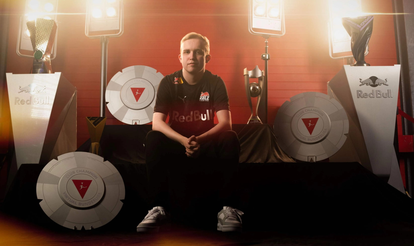 EA FC esports player posing with trophies after winning a Red Bull–sponsored virtual football championship