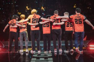 NRG players standing arm in arm on stage after winning VALORANT Champions 2025 in Paris, celebrating their first international trophy