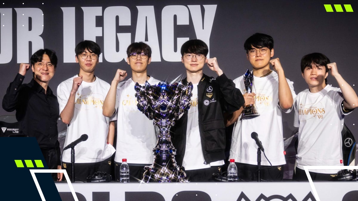 A team of Honor of Kings esports players stands on stage around a golden trophy during a large arena championship ceremony, with presenters on both sides and a cheering crowd in the background