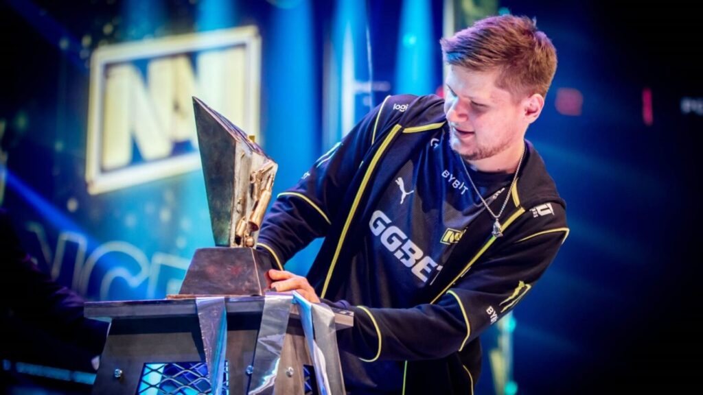 s1mple lifts a Counter-Strike trophy on stage after winning a major with Natus Vincere