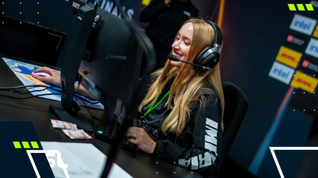 A smiling esports player wearing a headset and gaming at an ESL event