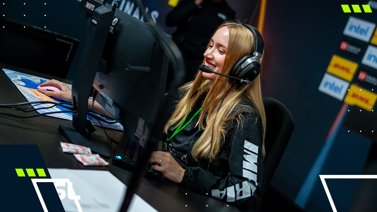 A smiling esports player wearing a headset and gaming at an ESL event