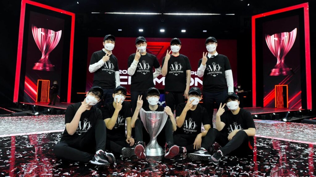T1 team celebrates their League of Legends LCK championship victory on stage with the trophy