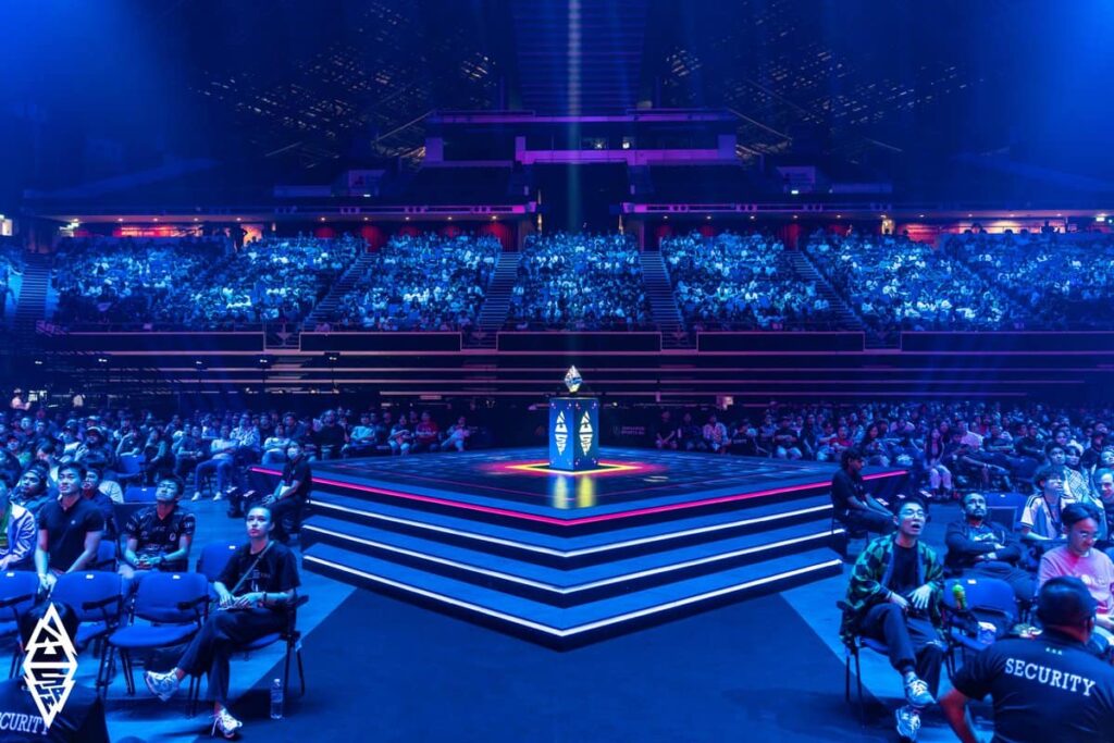 A packed arena watching the illuminated central stage before a match at BLAST Slam V