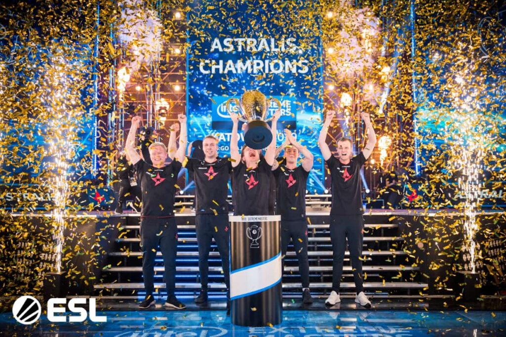 Astralis players celebrate a Counter-Strike 2 championship victory while lifting the trophy on stage