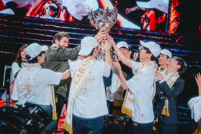 Esports team celebrating on stage after winning a major tournament and lifting the championship trophy