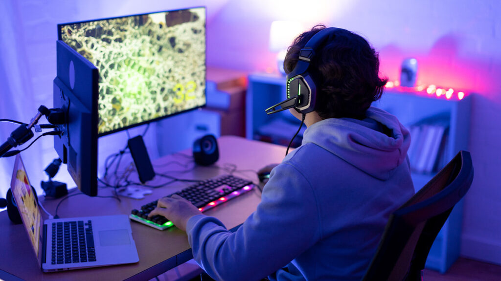 Esports player wearing a headset while competing at a PC gaming setup during an online match
