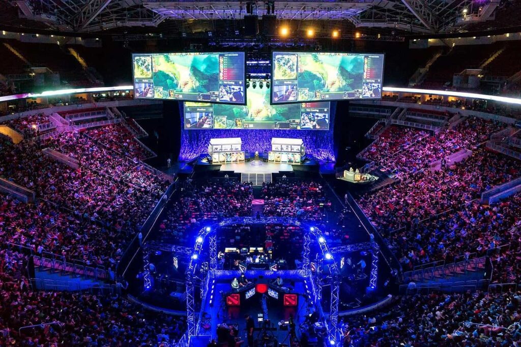 Massive international esports tournament with thousands of spectators watching live matches on giant arena screens