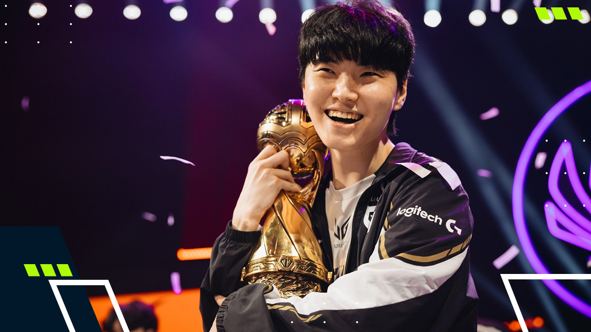 A League of Legends player smiles while hugging a golden trophy during a 2025 victory celebration