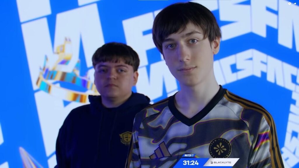 Two Fortnite esports players standing on stage in team jerseys