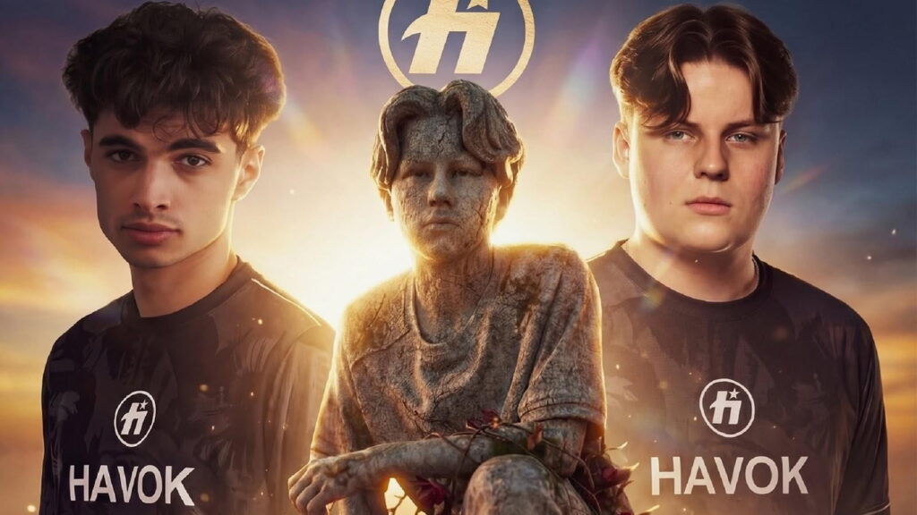 Two Fortnite professional players wearing Team HavoK jerseys stand beside a stone statue figure