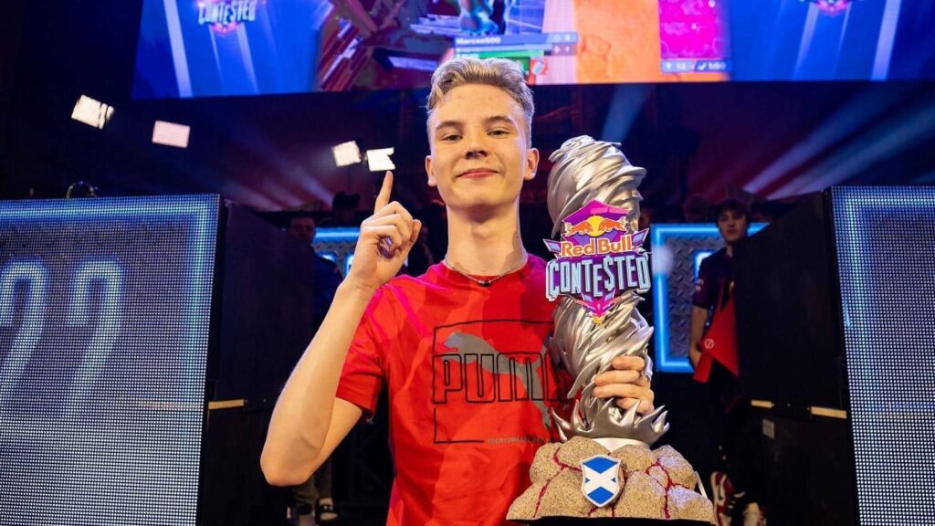 Fortnite esports player celebrating on stage while holding the Red Bull Contested trophy
